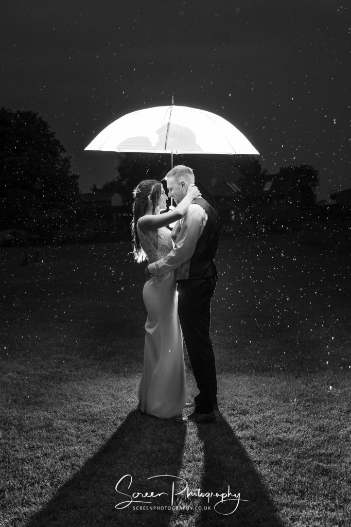 Bride groom wet raining umbrella photograph image monochrome black white
