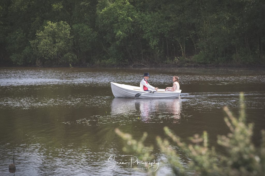 bride and Groom couple rowing on the lake Peak District darwin lake holiday village cottages