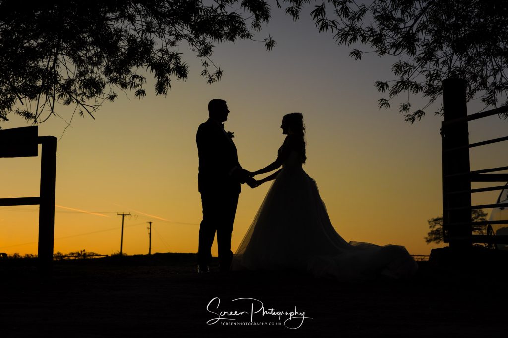 Swancar Farm wedding couple at sunset, silhouette in wedding dress and suit