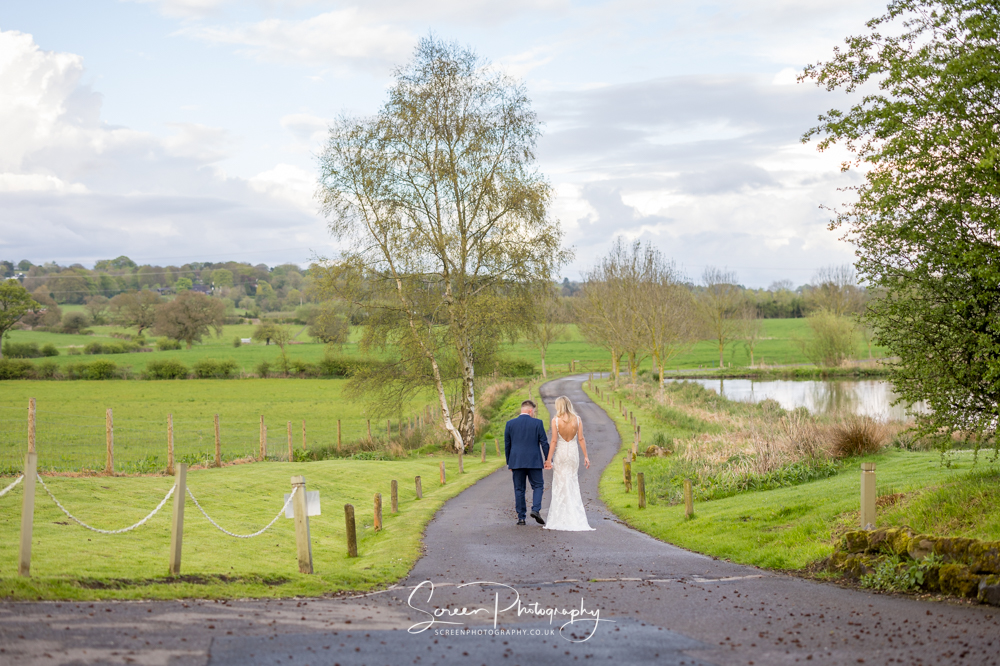 The Ashes Barns wedding couple male female walking down the drive