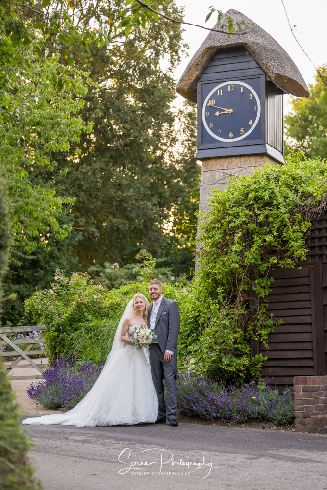 Clock Barn wedding venue Hampshire  in front of clock couple natural portrait