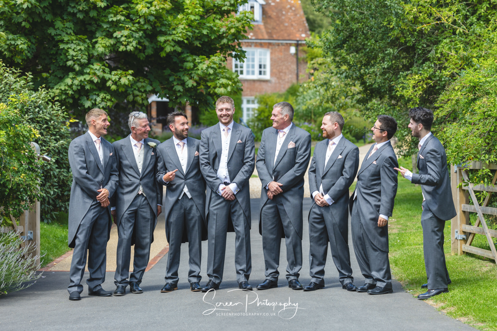 Clock Barn wedding venue Hampshire groom party men male standing in line having fun