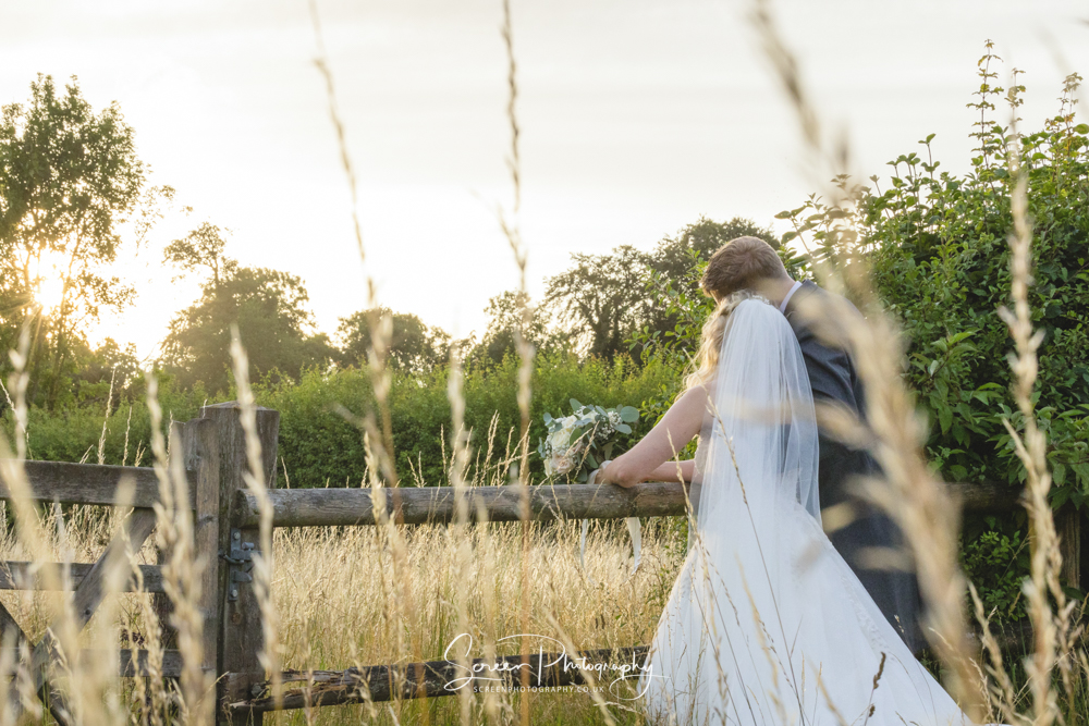 Clock Barn wedding venue Hampshire sunset sunburst evening couple portrait with bride and groom