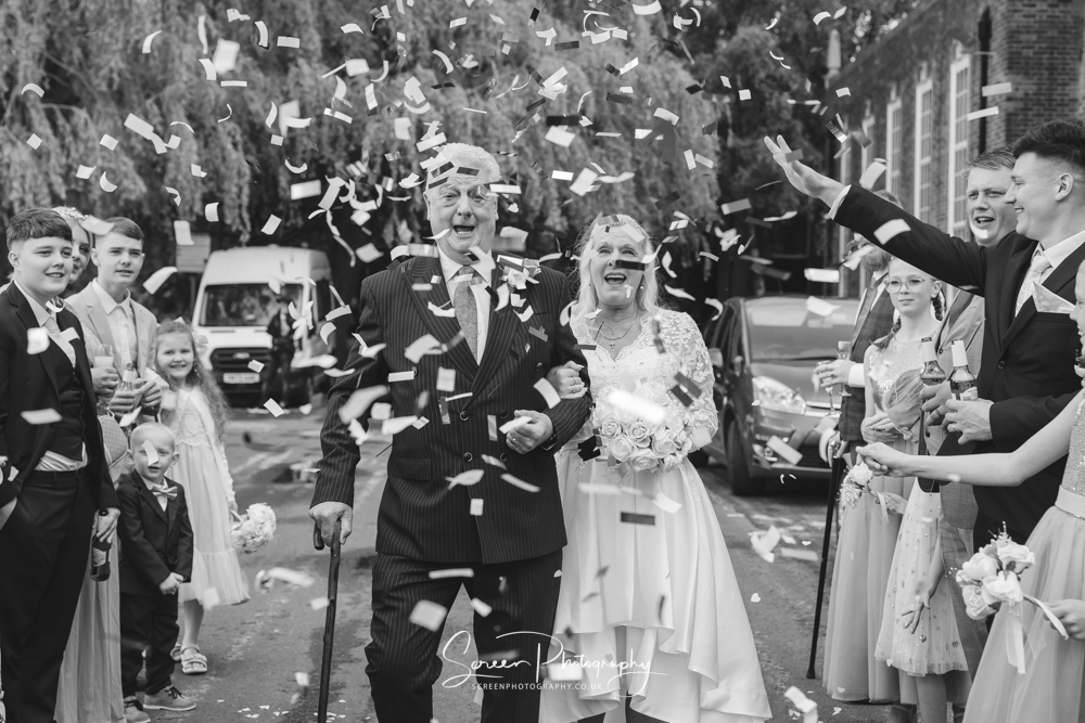 the derby conference centre married couple bride groom outside art deco having confetti thrown over them black white monochrome