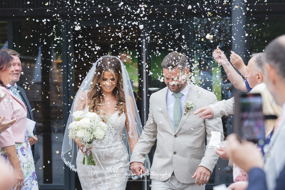 Bride groom male female married couple smiling happy during confetti walk foxtail barn stoke staffordshire