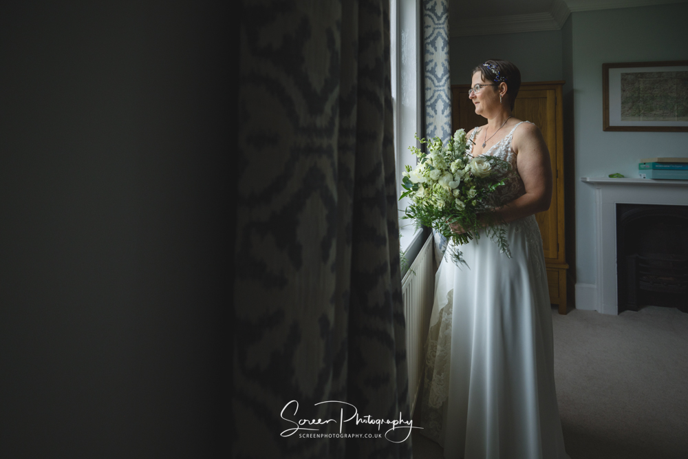 The Mill Hoveringham wedding barn watermill venue bride in natural light window with flowers
