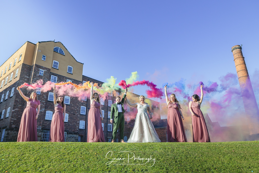 LGBTQ+ female wedding The West Mill Derby lesbian gay Same sex wedding bridal party with flares smoke grenades