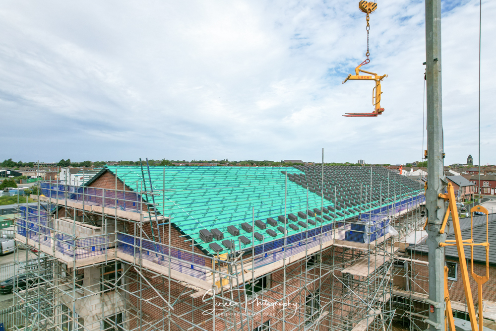 construction drone nottingham roof top with crane and slate tiles on building site