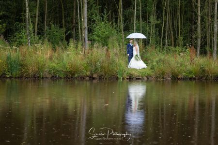 darwin lake wedding photography bride groom in rain over lake reflection with umbrella