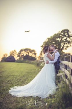 Donington Park Farmhouse wedding venue Leicestershire married couple bride groom at sunset in field with aeroplane above