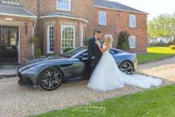 Swancar Farm House wedding venue Nottingham trowel married couple bride groom outside with Aston Martin car