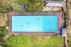commercial drone nottingham aerial view looking down of outdoor lido swimming pool with swimmers