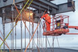 commercial drone nottingham of man welding cutting steel from high platform
