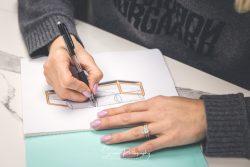 commercial portfolio photography nottingham close up of a lady designing a outdoor furniture using pen and paper