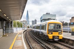 commercial photography nottingham on train station platform with blurred fat moving train and london the shard in distance
