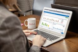 commercial photography nottingham showing a lady working at a laptop with graphs and data on screen with a mug on the desk